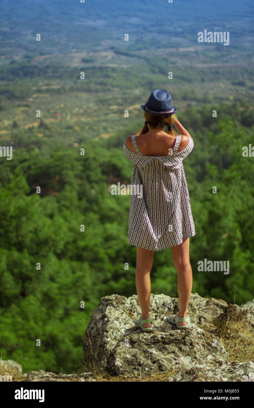 Caucasian woman in a dress photographing mountains Stock Photo