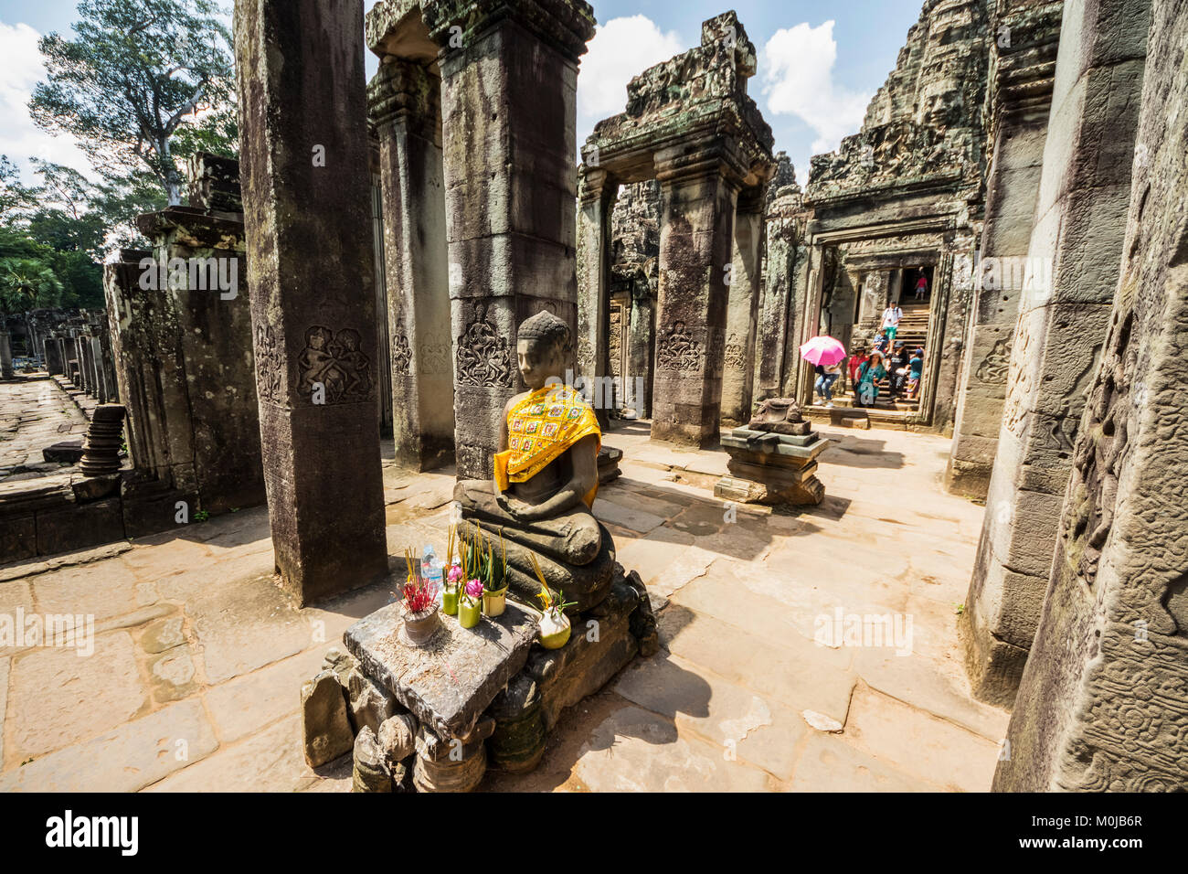 Buddha statue and North face of the Bayon, Angkor Thom; Siem Reap, Cambodia Stock Photo