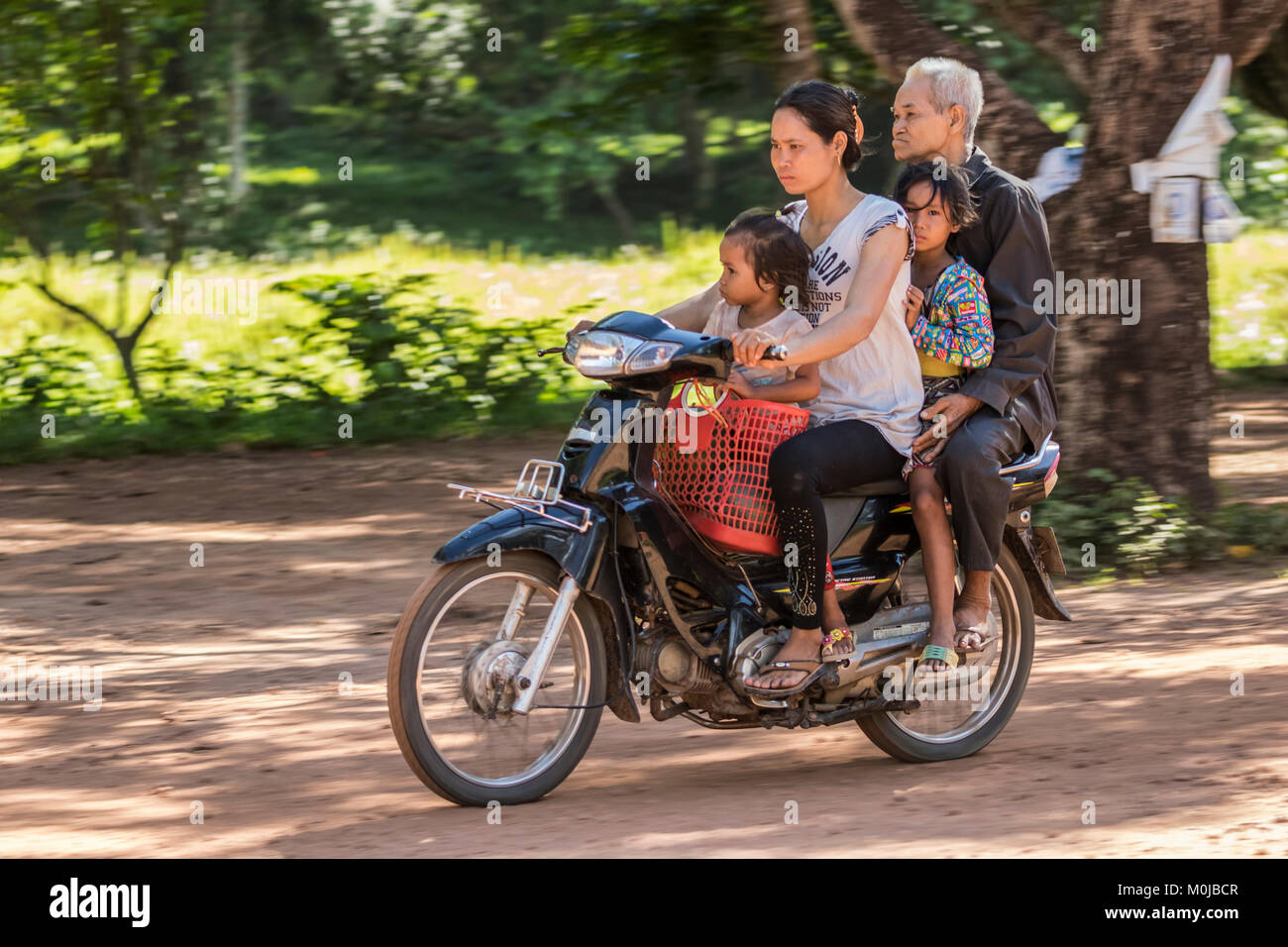 Cambodian family riding a motorcycle, Beng Meala; Siem Reap, Cambodia Stock Photo