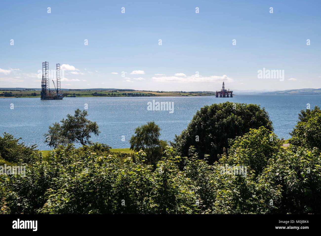 North Sea oil and gas rigs lined up in the sheltered waters of the Cromarty Firth for maintenance and refurbishment. Stock Photo