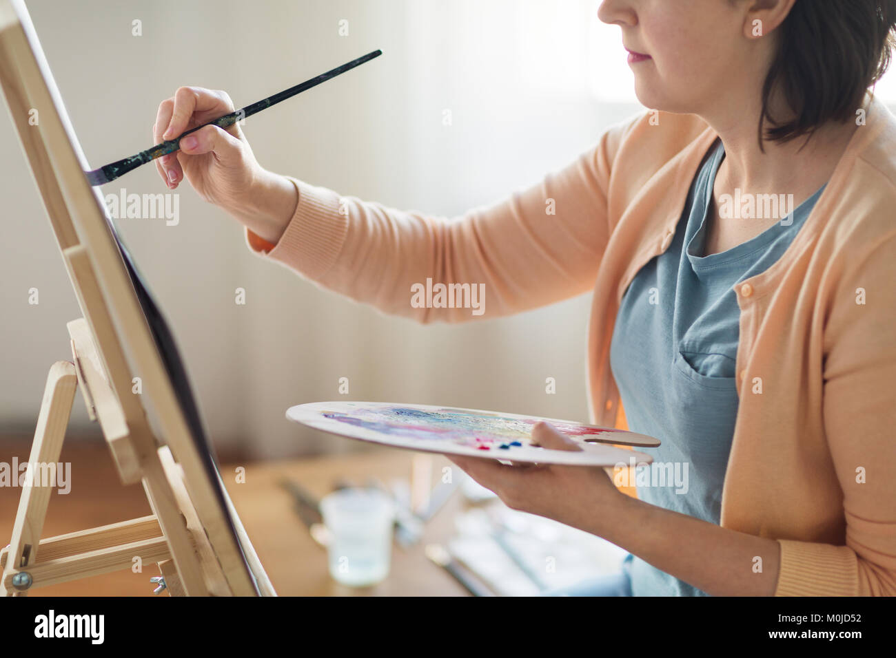artist with palette and brush painting at studio Stock Photo - Alamy