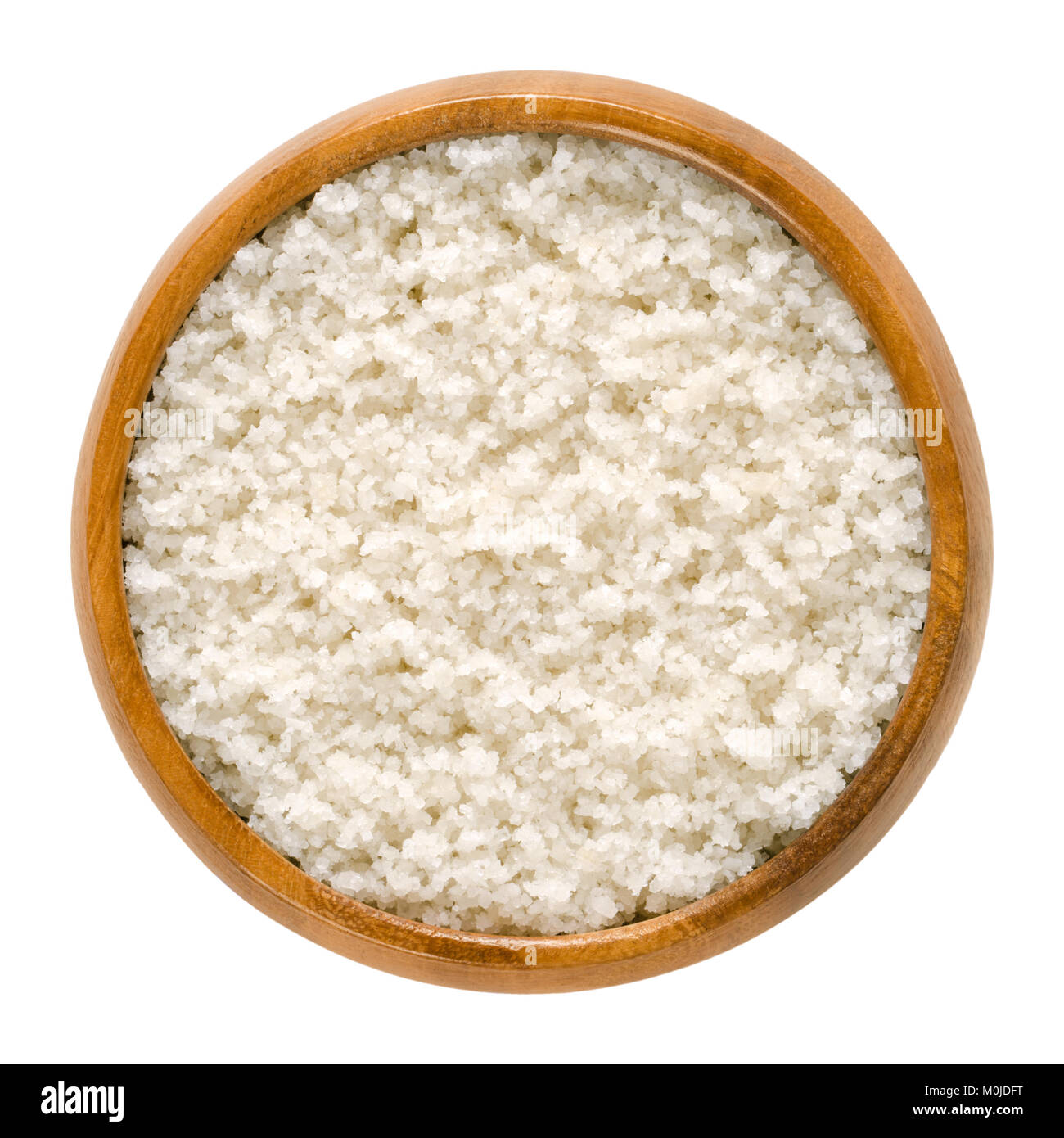 Atlantic sea salt in wooden bowl. Unrefined, unwashed, untreated, coarse salt without additives. Harvested from clay layer. Isolated macro food photo. Stock Photo