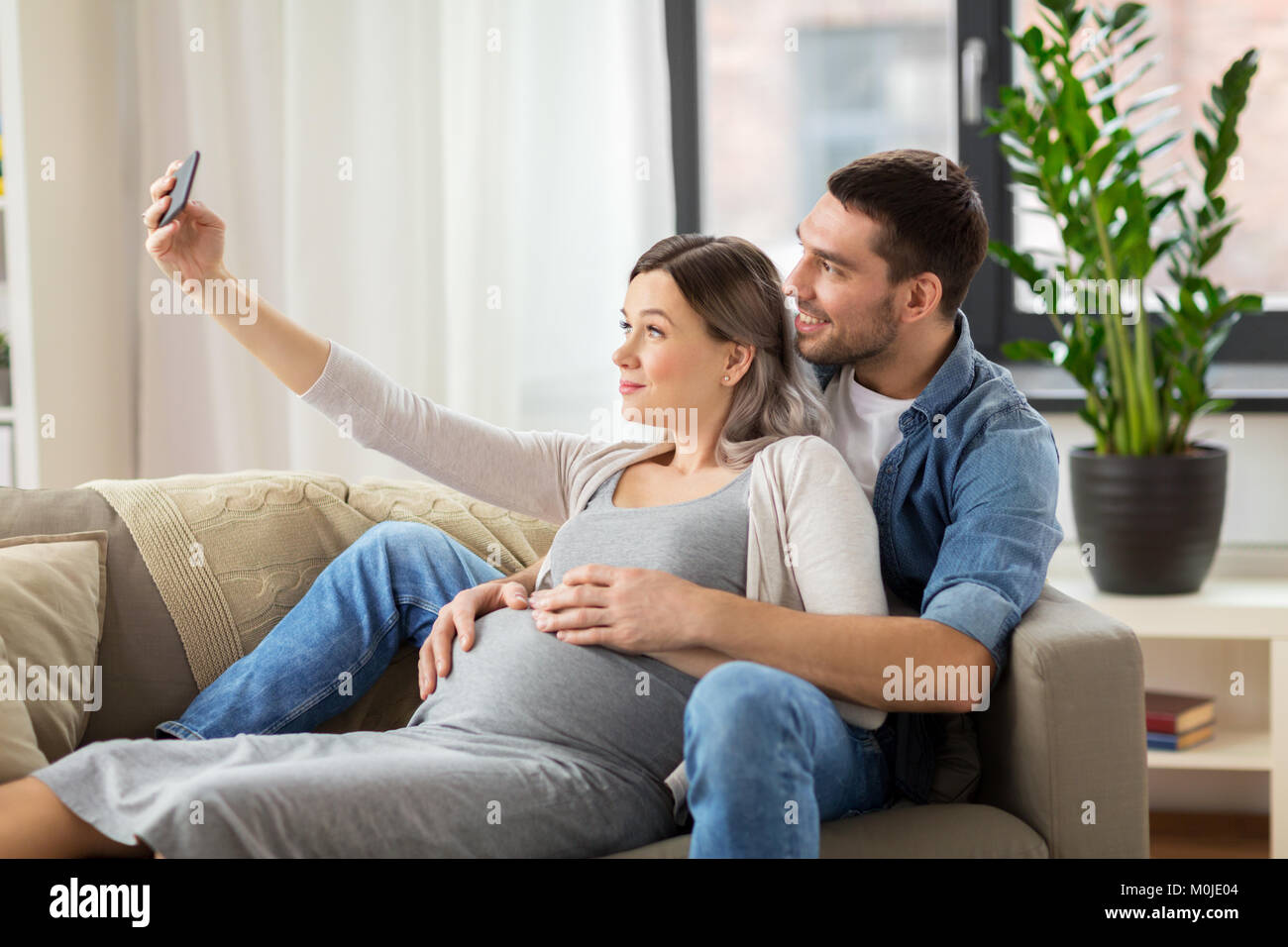man and pregnant woman taking selfie at home Stock Photo - Alamy