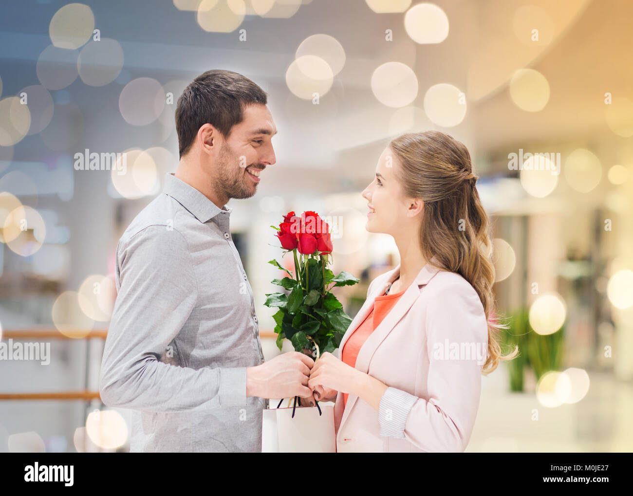 happy young couple with flowers in mall Stock Photo - Alamy