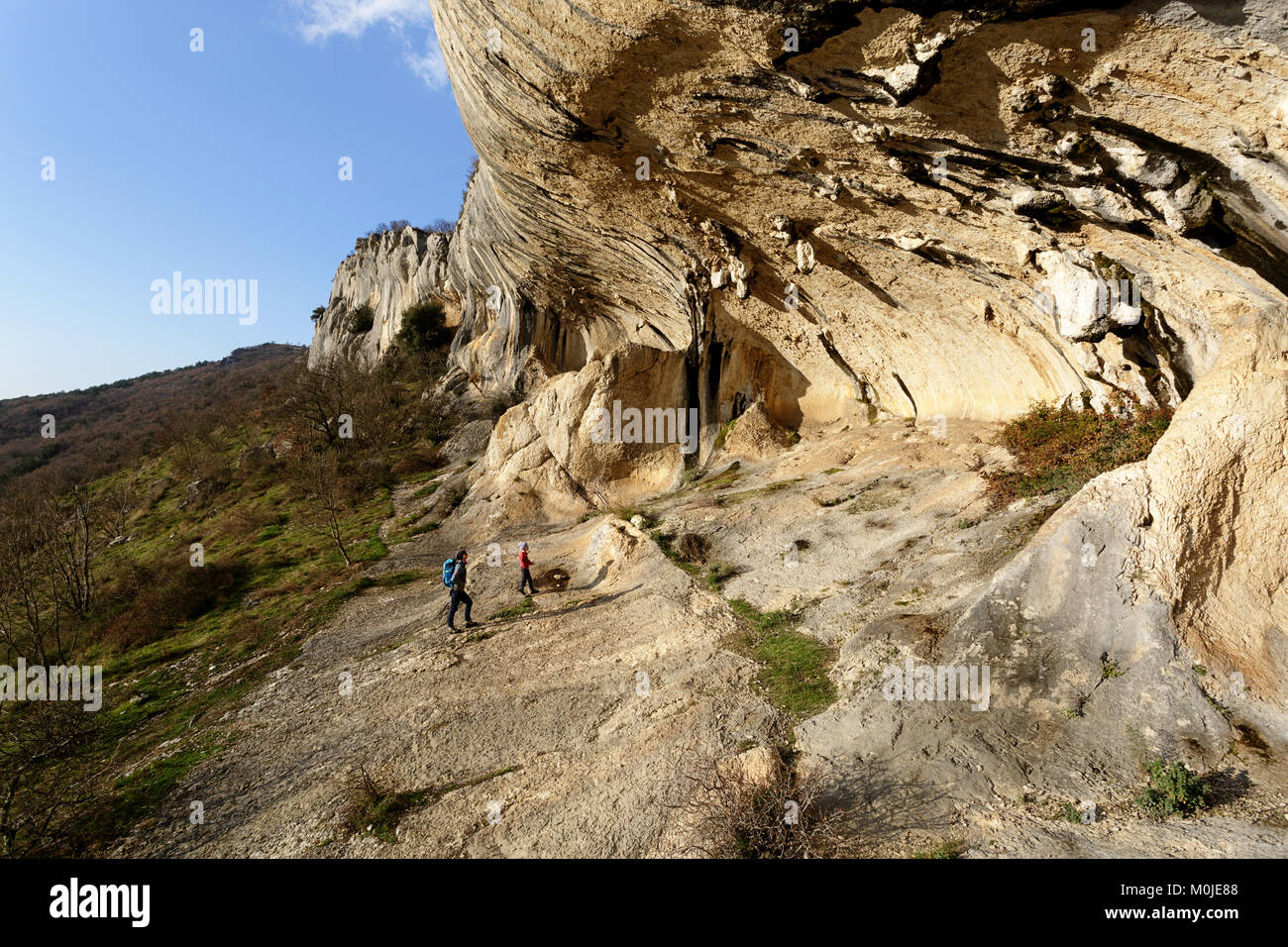 Mother and son under karst rock formations and cliffs at Veli badin, Socerga, Slovenia. Stock Photo