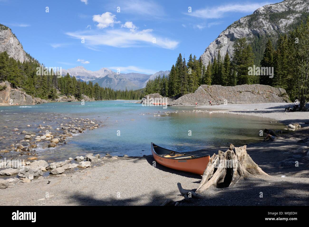 A kayak sitting on the gravel shore of the Bow River in Banff, Alberta, Canada. Stock Photo