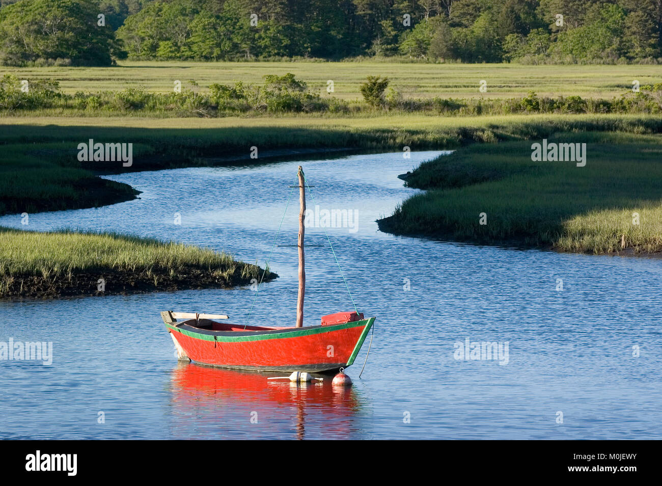 A moored sailing dory, makes a visual arts display along the Herring River in Harwich Port, Massachusetts, Cape Cod, USA Stock Photo