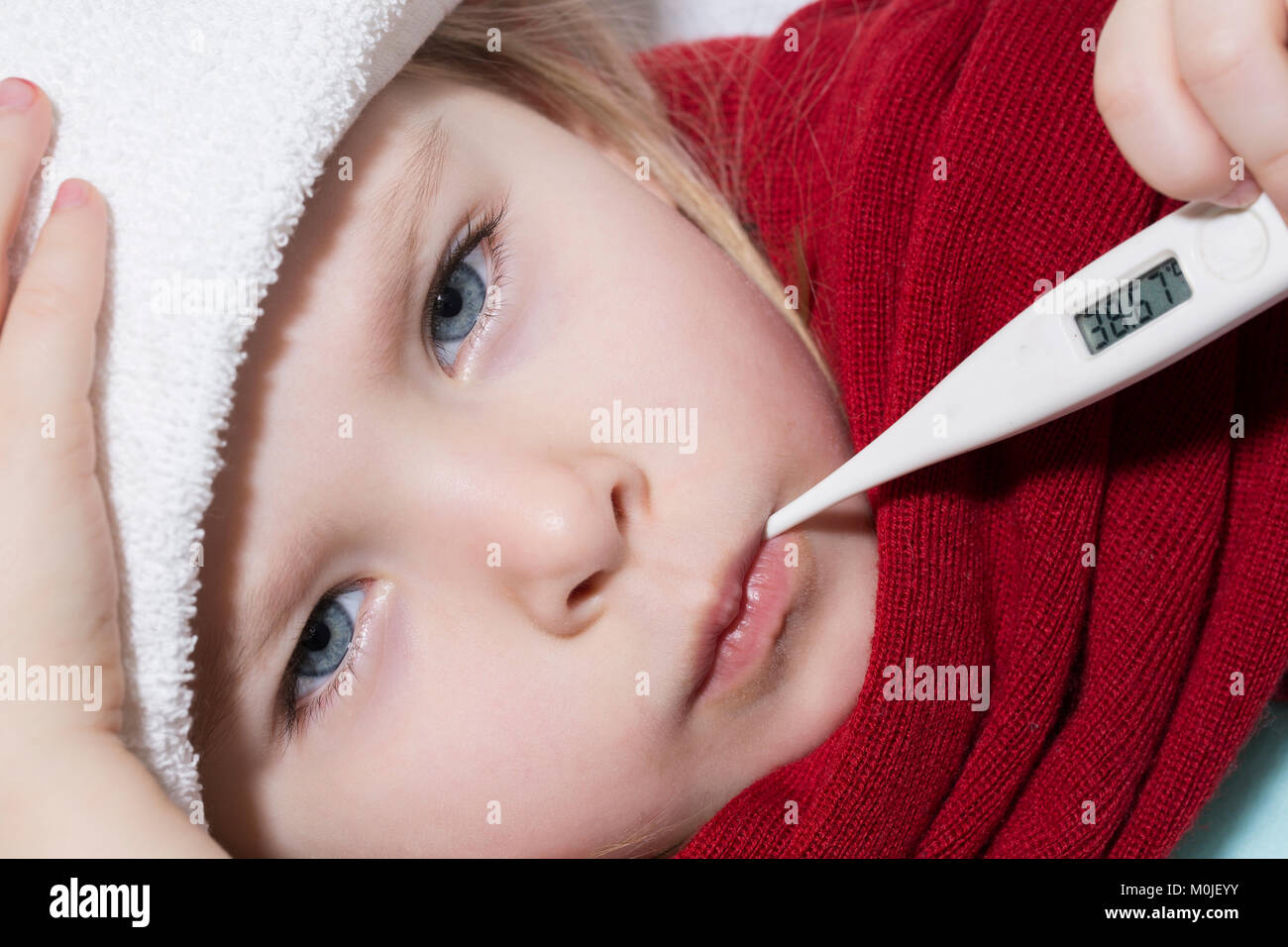 sick girl lying in bed with a thermometer in mouth Horizontal Stock Photo