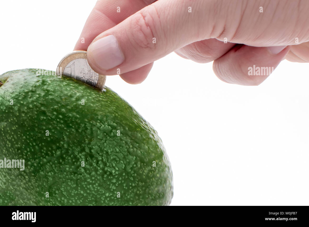 https://c8.alamy.com/comp/M0JFB7/avocados-as-a-piggy-bank-in-which-the-hand-puts-a-coin-M0JFB7.jpg