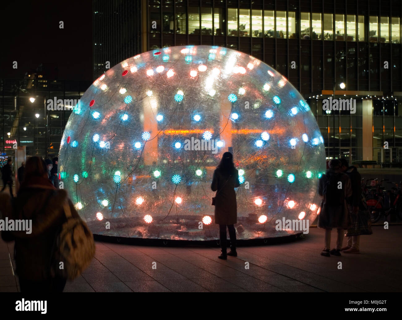 Visitors view an interactive installation called Sonic Light Bubble, part of the Winter Lights festival at Canary Wharf, in London, Britain 14, 2018. Stock Photo