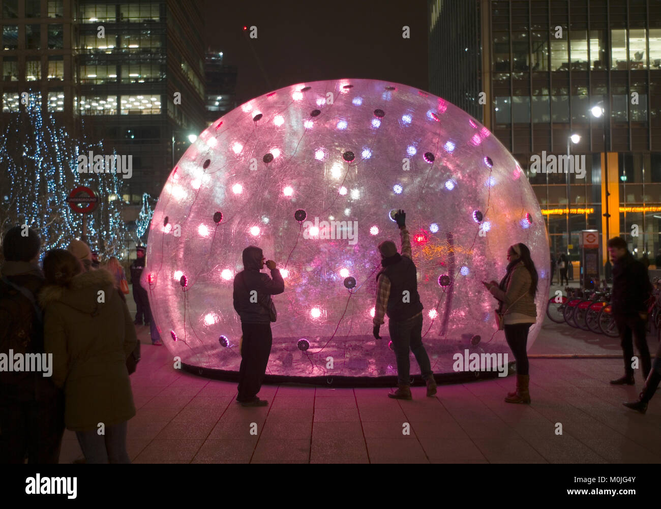 Visitors view an interactive installation called Sonic Light Bubble, part of the Winter Lights festival at Canary Wharf, in London, Britain 14, 2018. Stock Photo