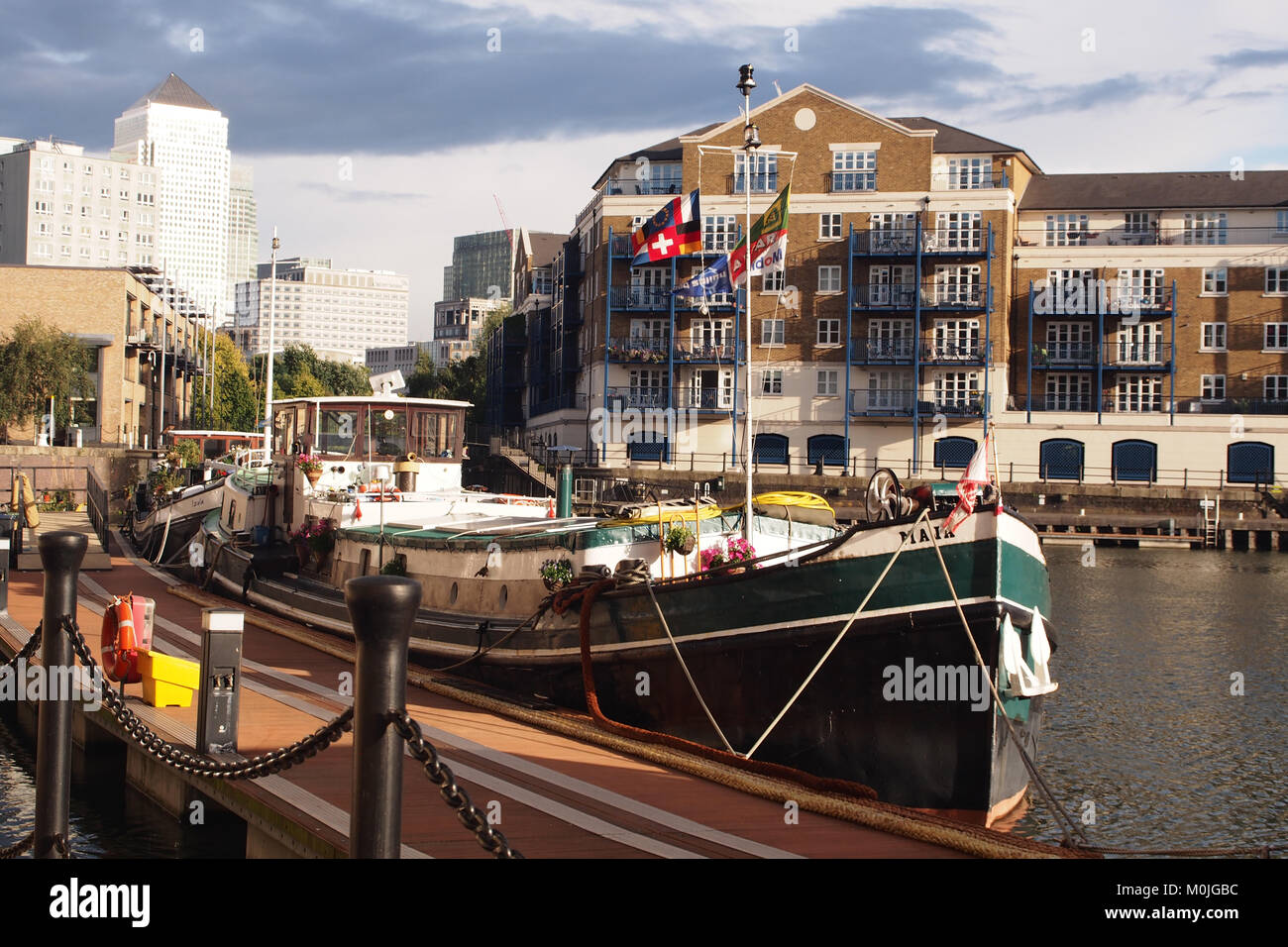 A house boat moored at Limehouse basin, east London with the financial district of Canary Wharf and residential properties in the background Stock Photo