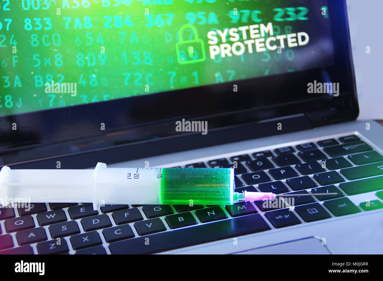 System protection concept and cybersecurity. Antivirus vaccination in the syringe applied to the computer. Stock Photo