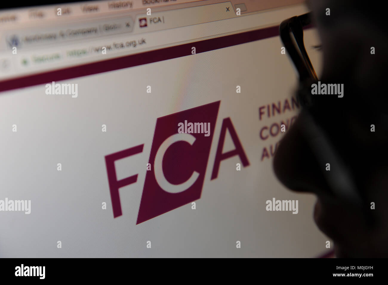 A woman looks at the The Financial Conduct Authority website Stock Photo