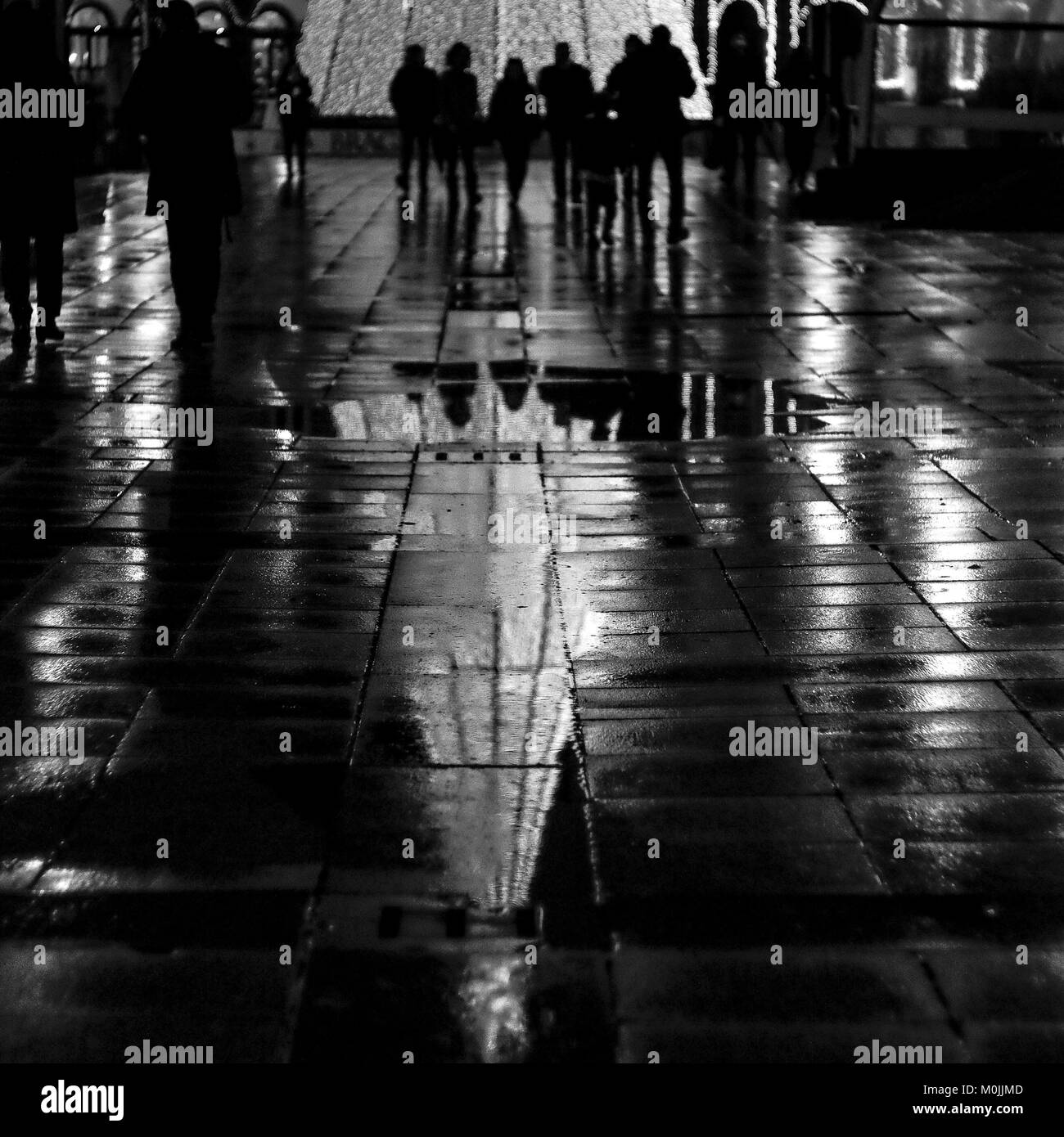 People walking around he bright lights of Christmas tree and city