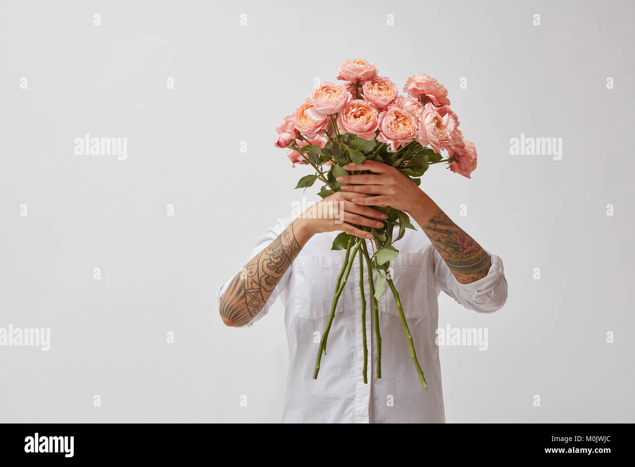 the girl is holding a bouquet of fresh pink roses Stock Photo - Alamy