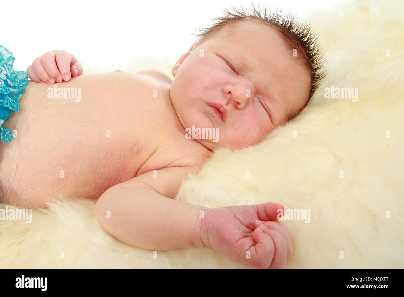 newborn baby boy sleeping on rug Stock Photo