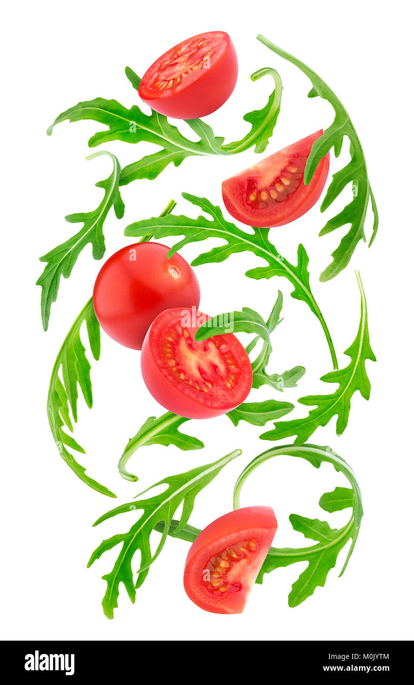 Falling fresh vegetables. Cherry tomatoes and rucola isolated on white background with clipping path Stock Photo