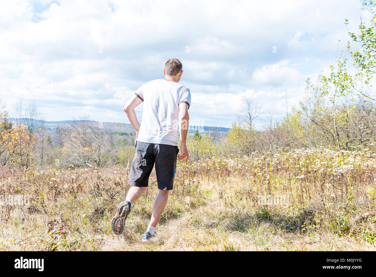 Young athletic, fit, free happy man running jogging jumping in autumn ...