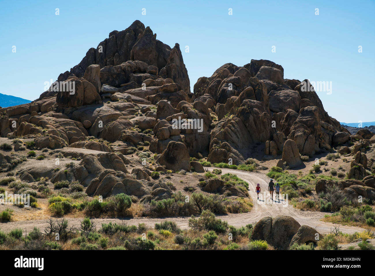 Family walking down a road in the Alabama Hills; California, United States of America Stock Photo