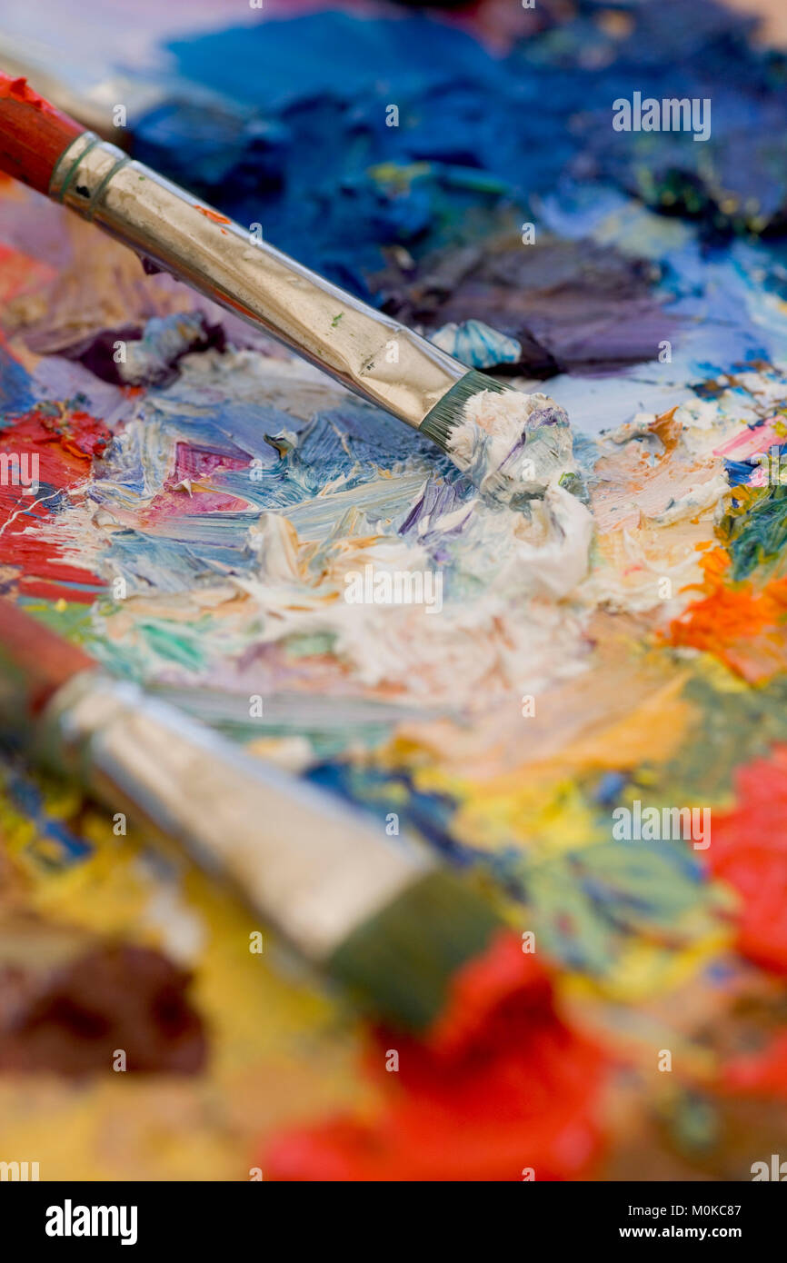 Paintbrushes, artist palette, oil paints on desk in painter studio. Close  up Stock Photo - Alamy