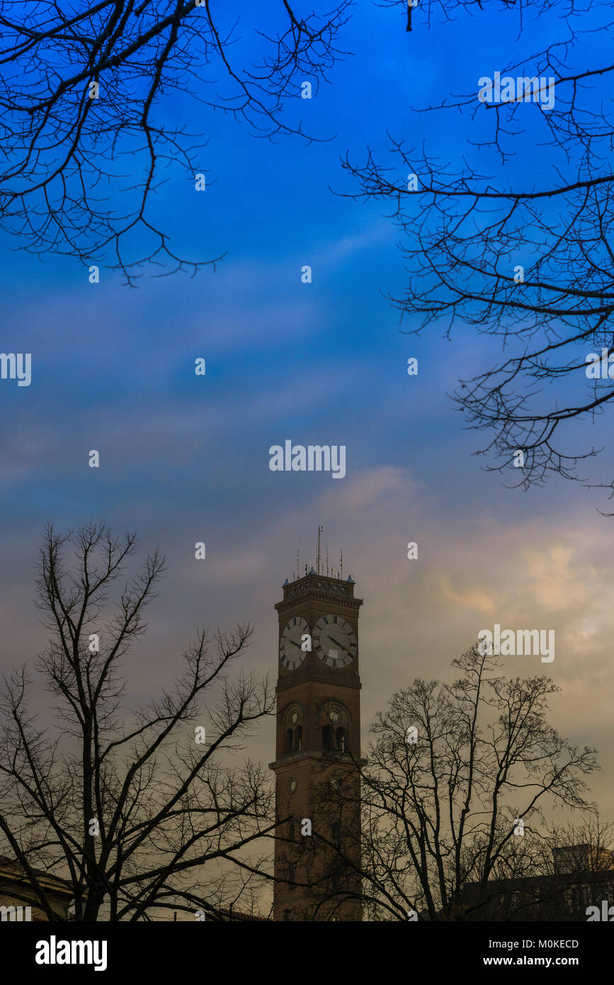 Small civic tower at blue hour, among of tree braches Stock Photo