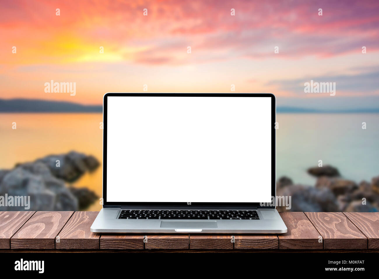 Modern laptop with empty white screen on wooden table against blurred ...