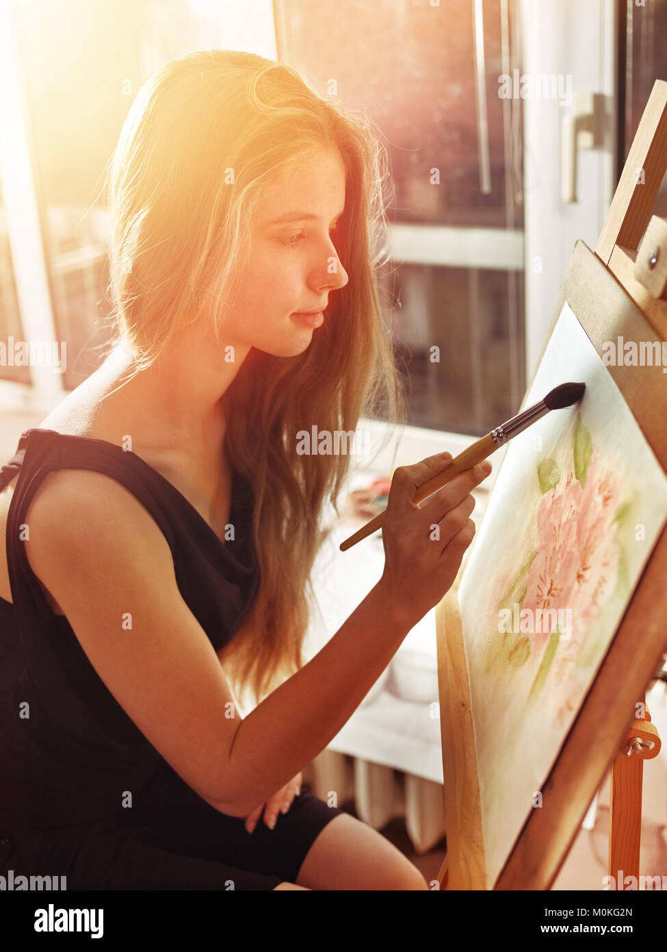 Artist painting on easel in studio. Girl paints with brush Stock Photo ...