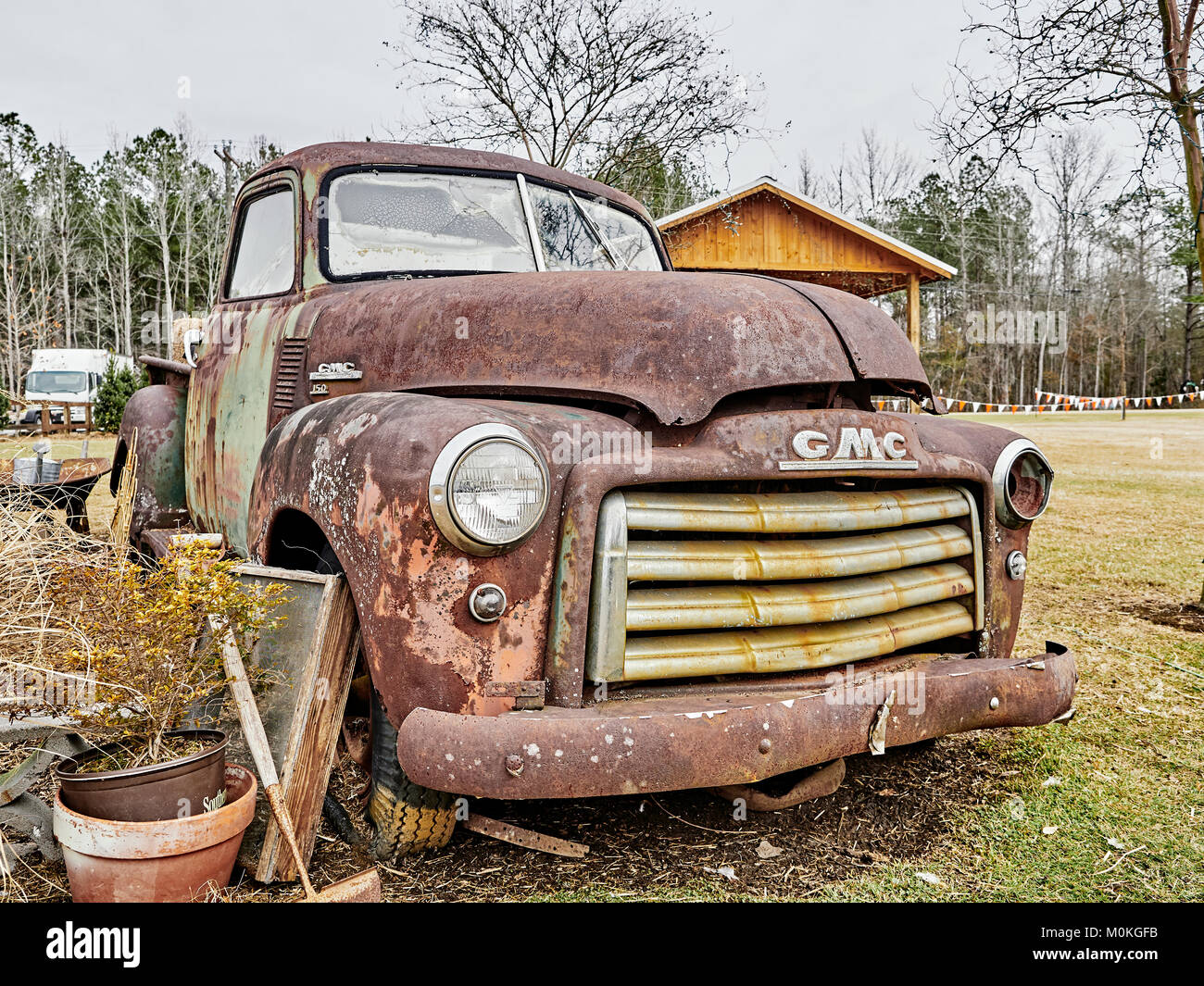 Old rusty abandoned vintage GMC 150 farm pick up truck parked in a field in rural Pike Road Alabama. Stock Photo