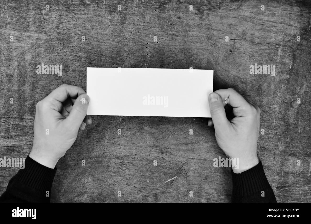 monochrome photo male hands holding a white blank sheet of paper Stock ...
