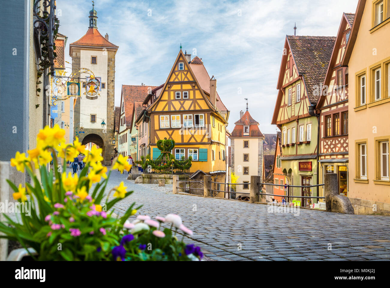 Classic view of the medieval town of Rothenburg ob der Tauber with blooming flowers on a beautiful sunny day in springtime, Bavaria, Germany Stock Photo