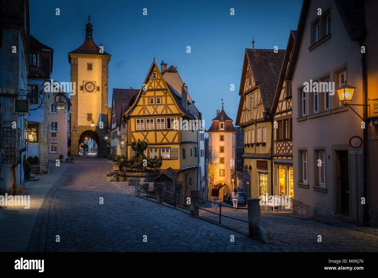 Classic view of the medieval town of Rothenburg ob der Tauber illuminated in beautiful evening twilight during blue hour at dusk, Bavaria, Germany Stock Photo