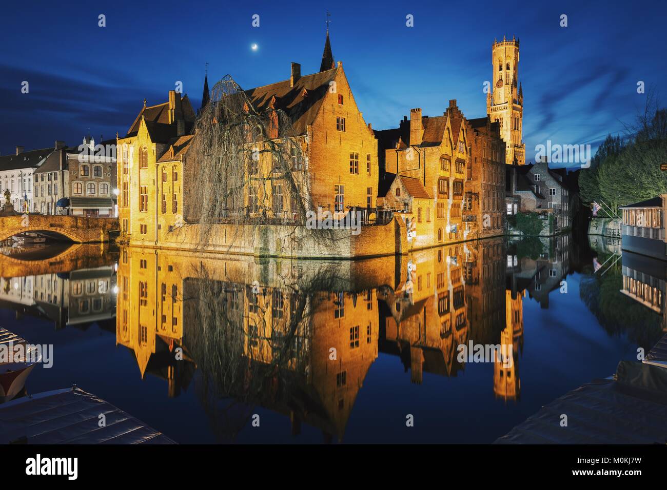 Classic view of the historic city center of Brugge with famous Rozenhoedkaai illuminated during magical twilight, Flanders, Belgium Stock Photo