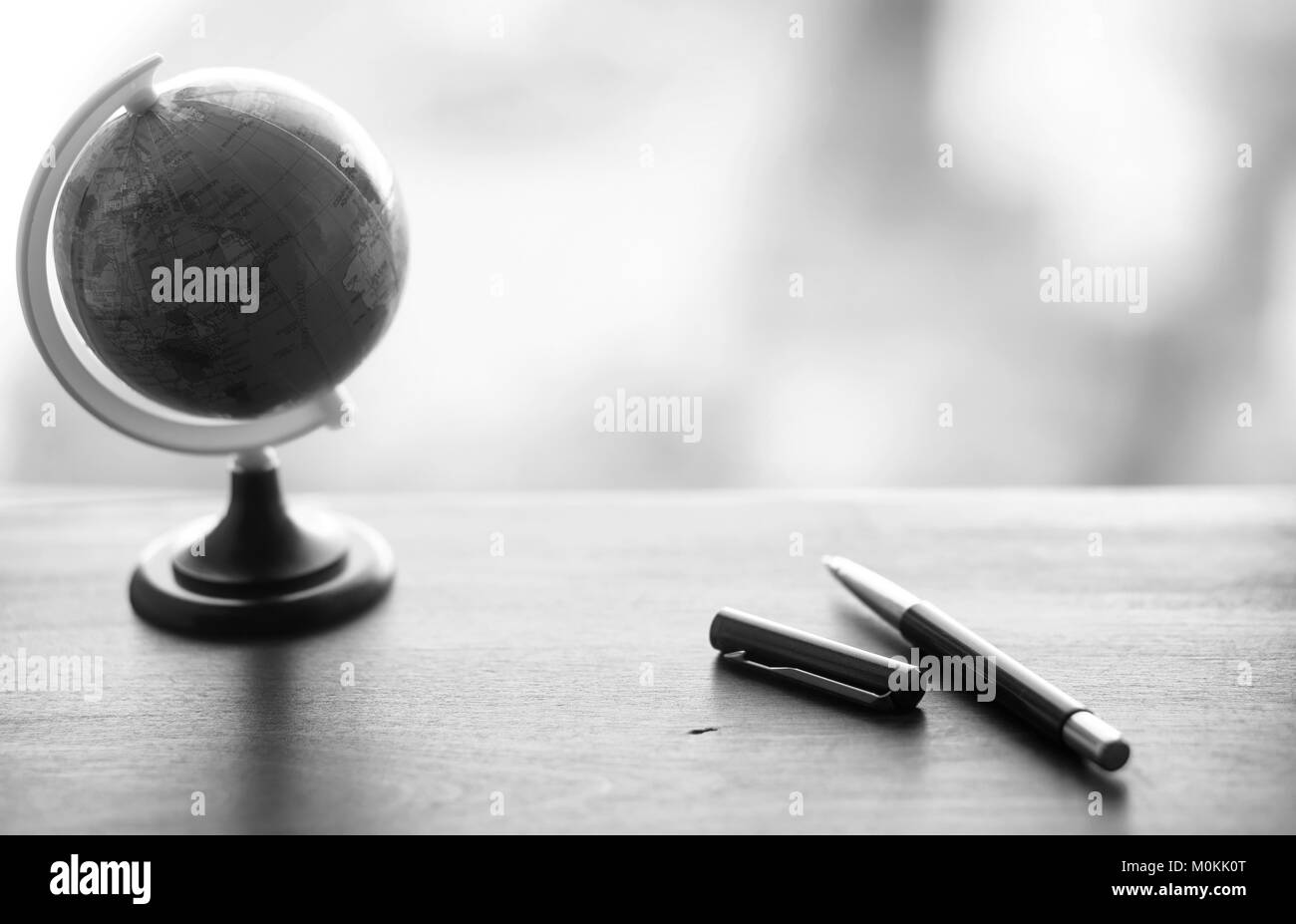 A pen on the desk with small globe Stock Photo Alamy