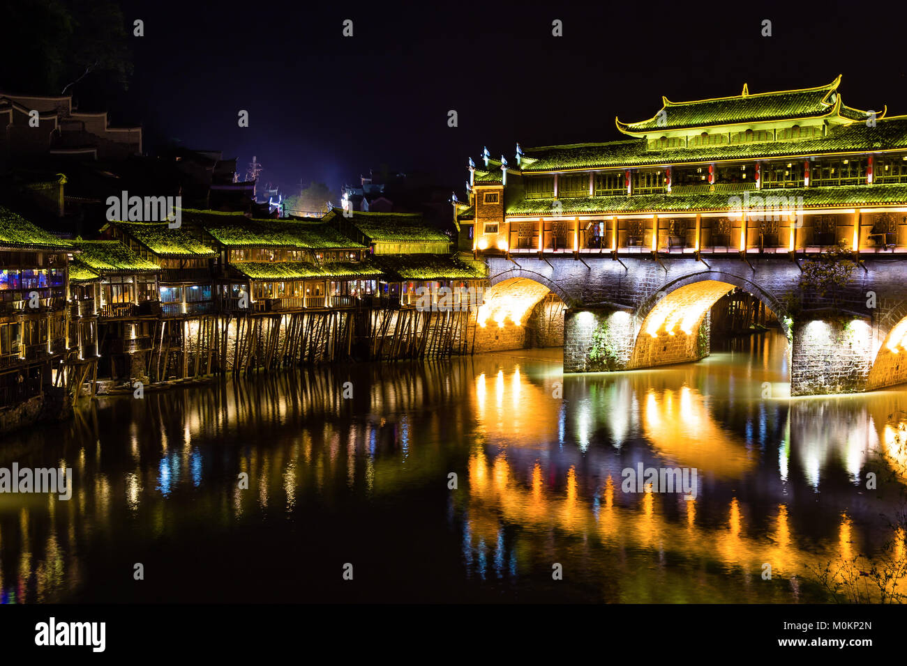Hong Bridge at night in Fenghuang Ancient town, Hunan province, China. This ancient town was added to the UNESCO World Heritage Tentative List in the  Stock Photo