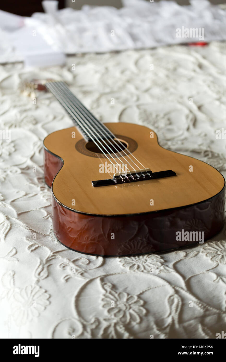 Spanish guitar lying on the bed Stock Photo Alamy