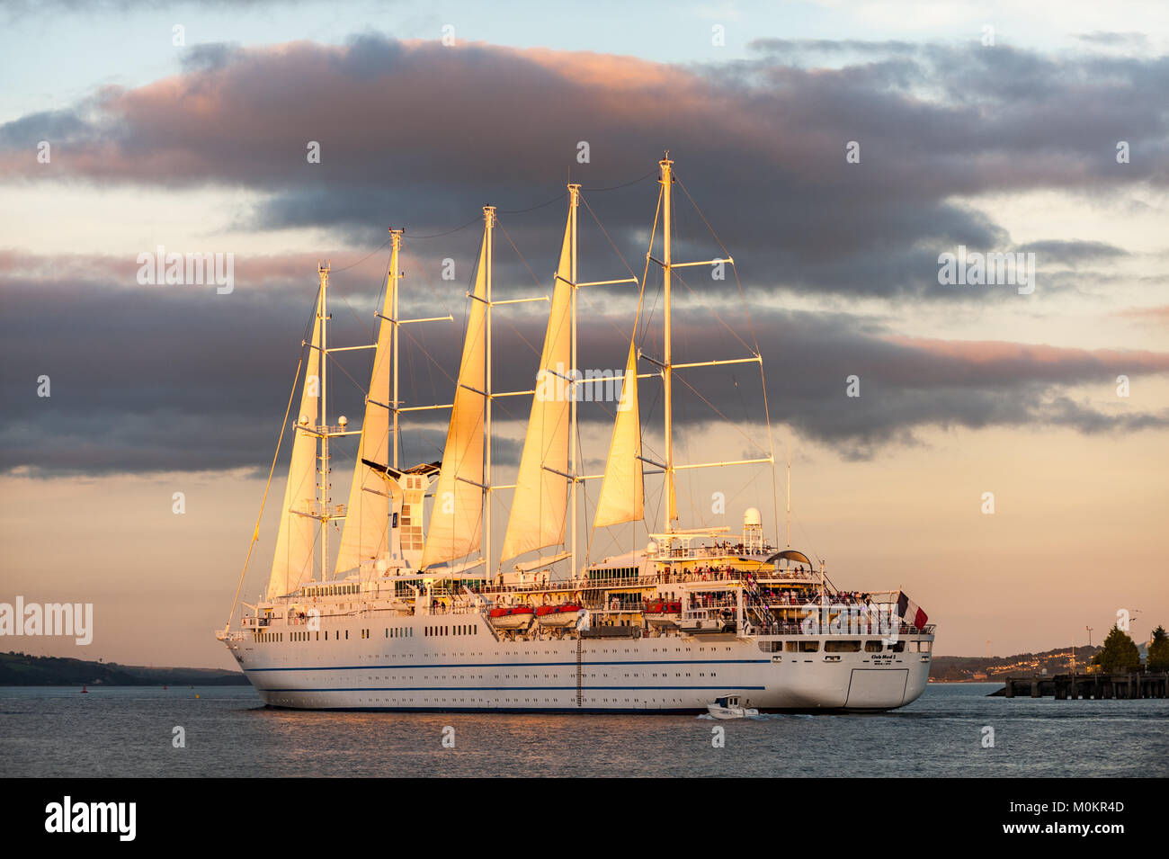 Staysail Schooner 'Club Med 2' sails through Cobh, Co. Cork, Ireland under a setting sun on the way to her next destination. Stock Photo