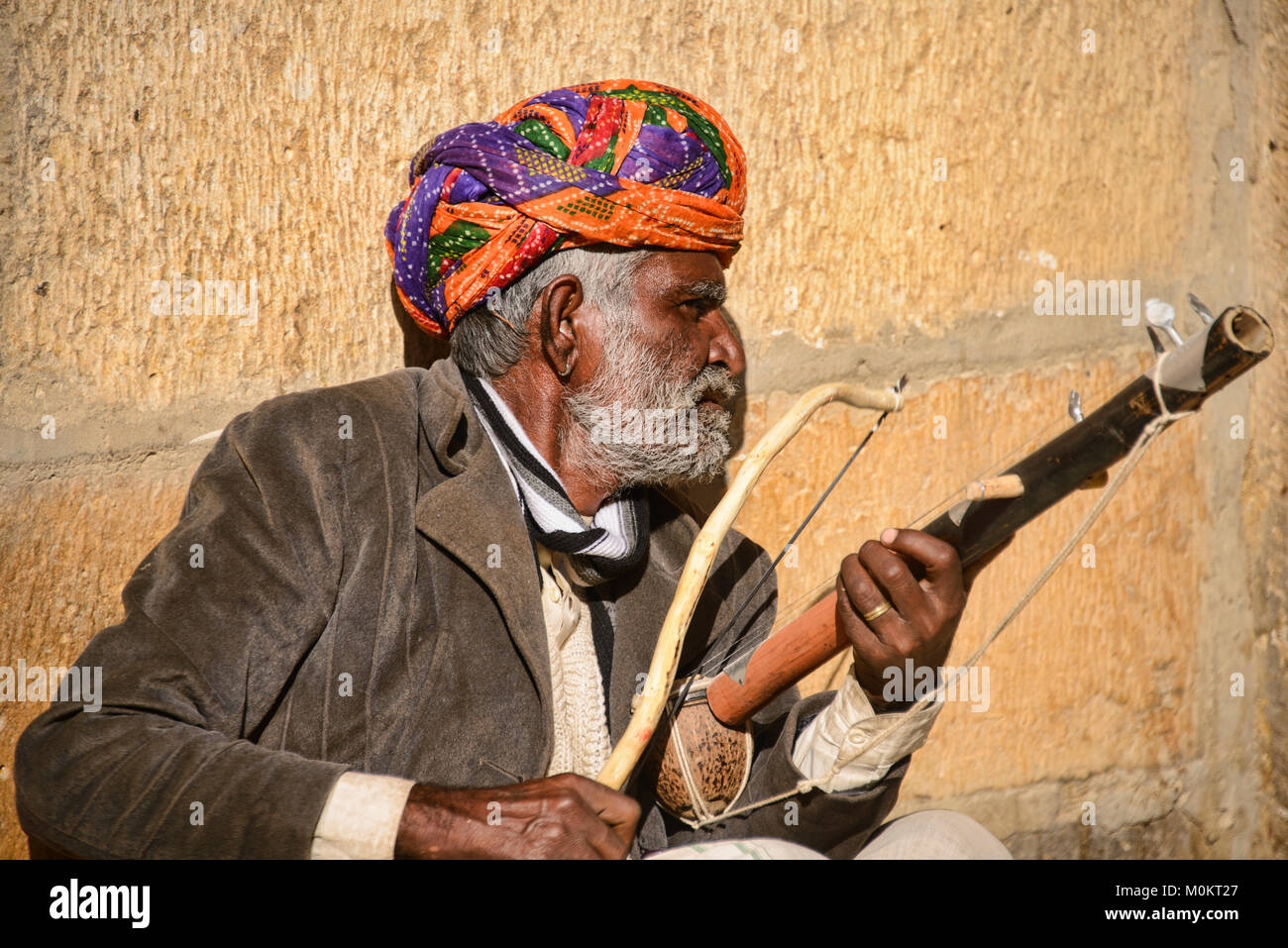 Man playing a musical instrument outside the Patwa Haveli Jaisalmer ...