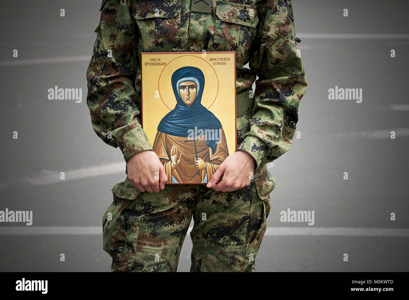 Soldier holding orthodox religious icon of saint Anastasia Stock Photo