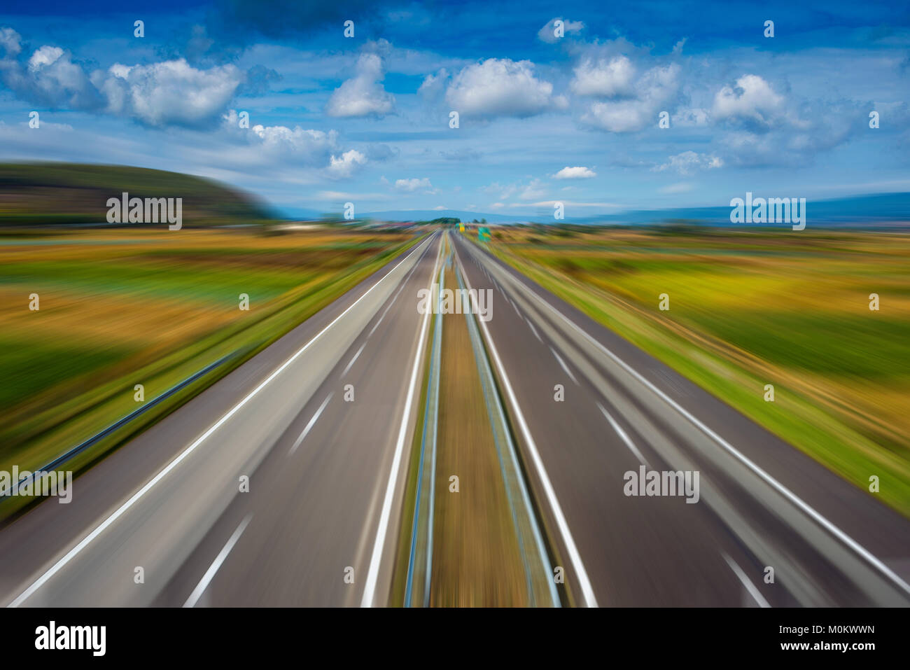 Zoom effect on empty modern highway going through fields Stock Photo