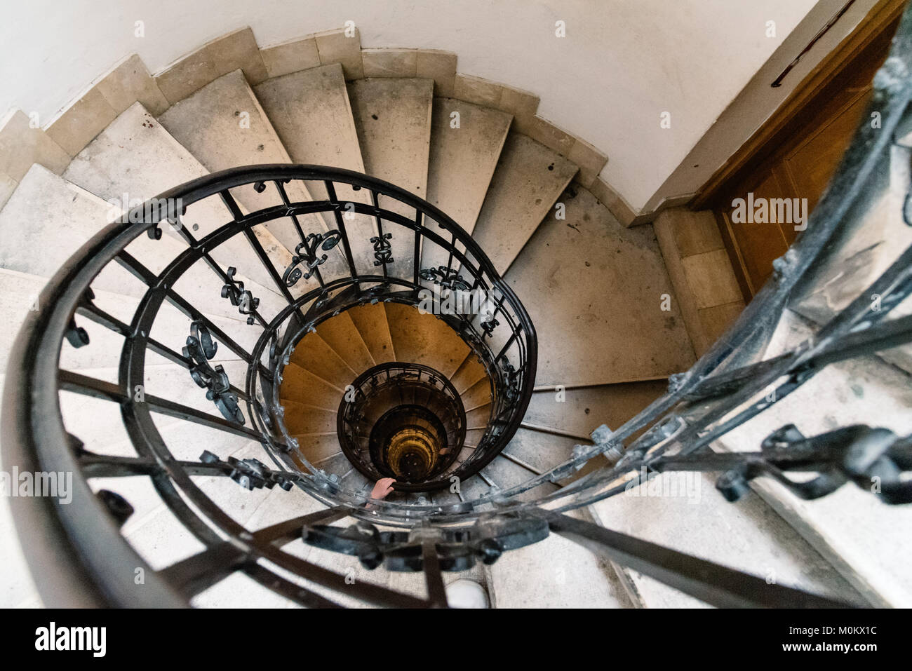 High angle view of spiral staircase with hand of man below. Stock Photo