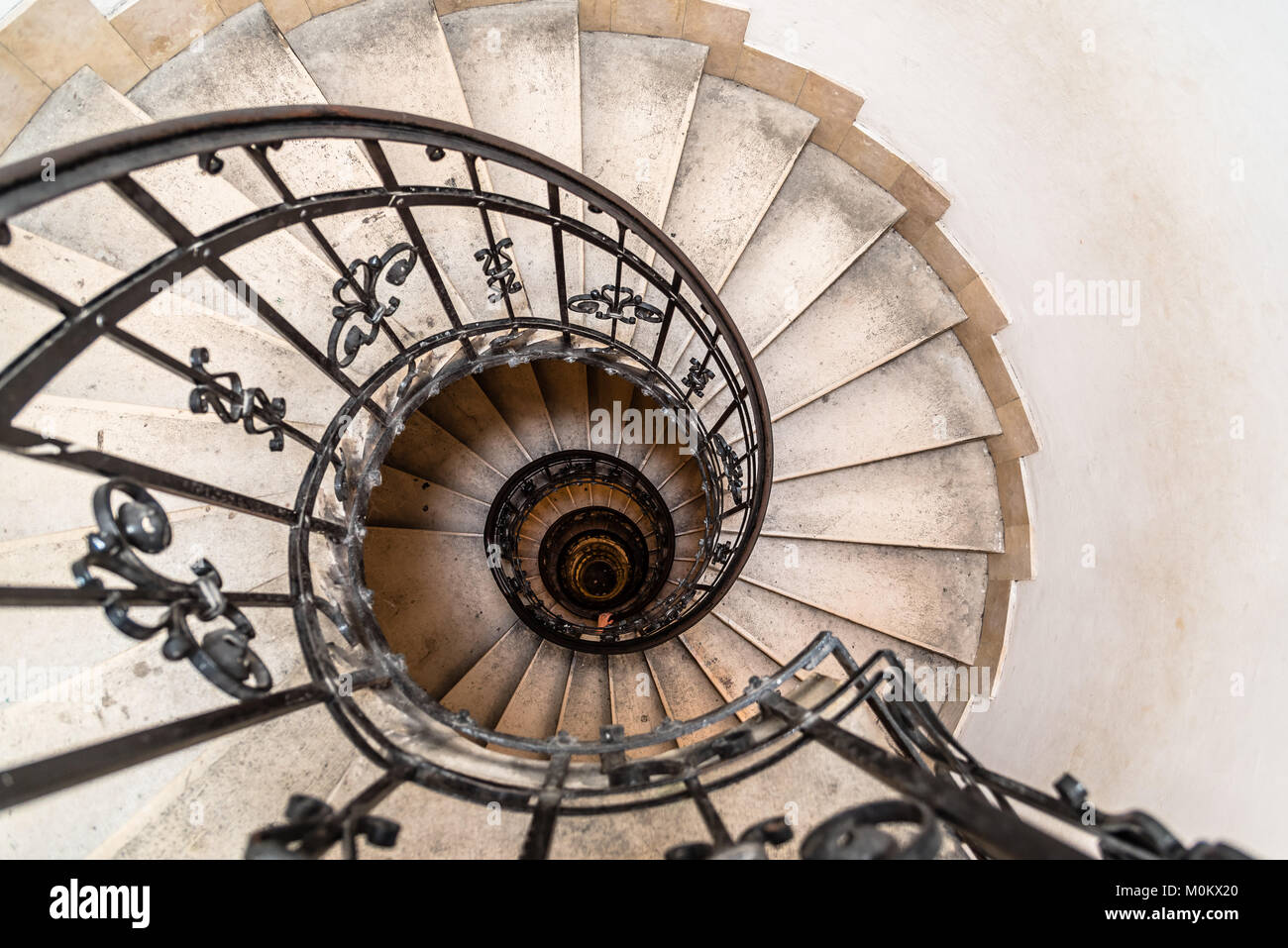 High angle view of spiral staircase with hand of man below. Stock Photo
