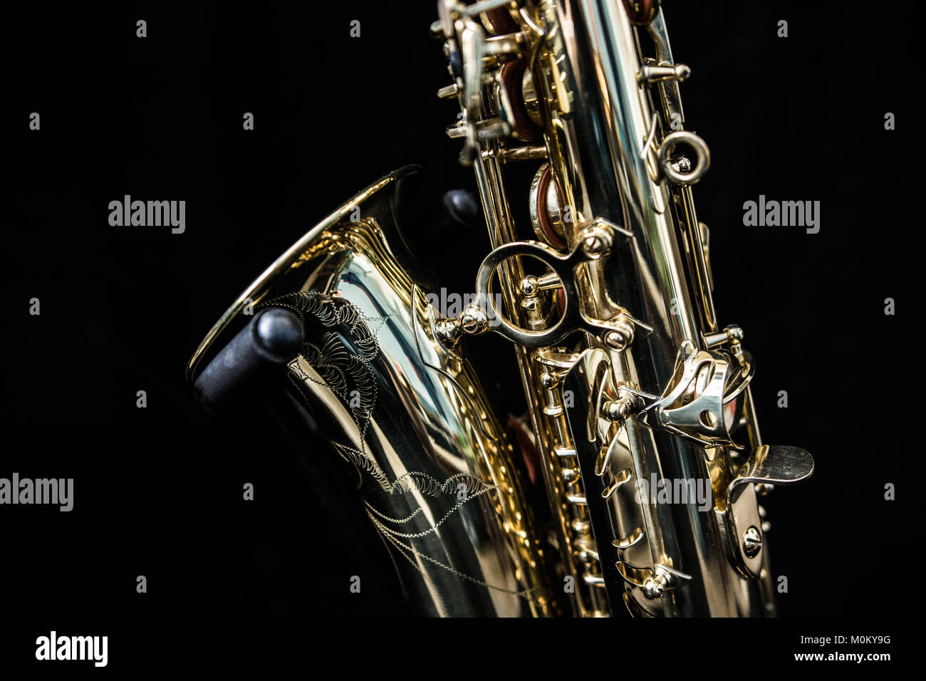 Close up of a standing golden saxophone isolated in black Stock Photo