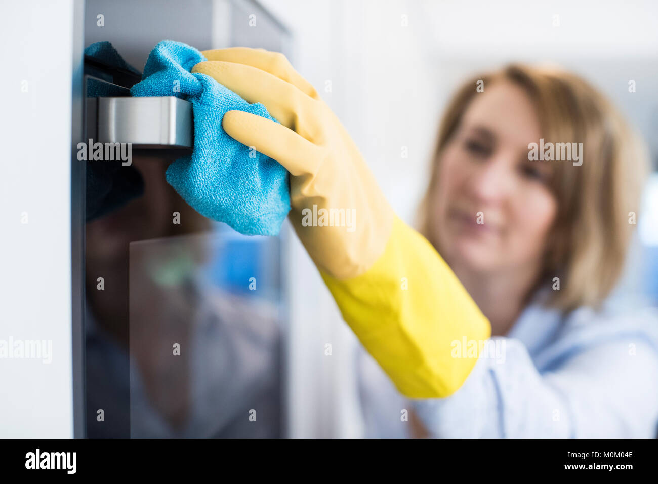 Close Up Of Woman Cleaning Oven In Kitchen Stock Photo