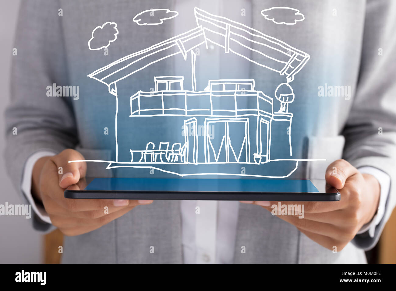 Midsection Of Businessperson Showing Model Home Over Digital Tablet Stock Photo