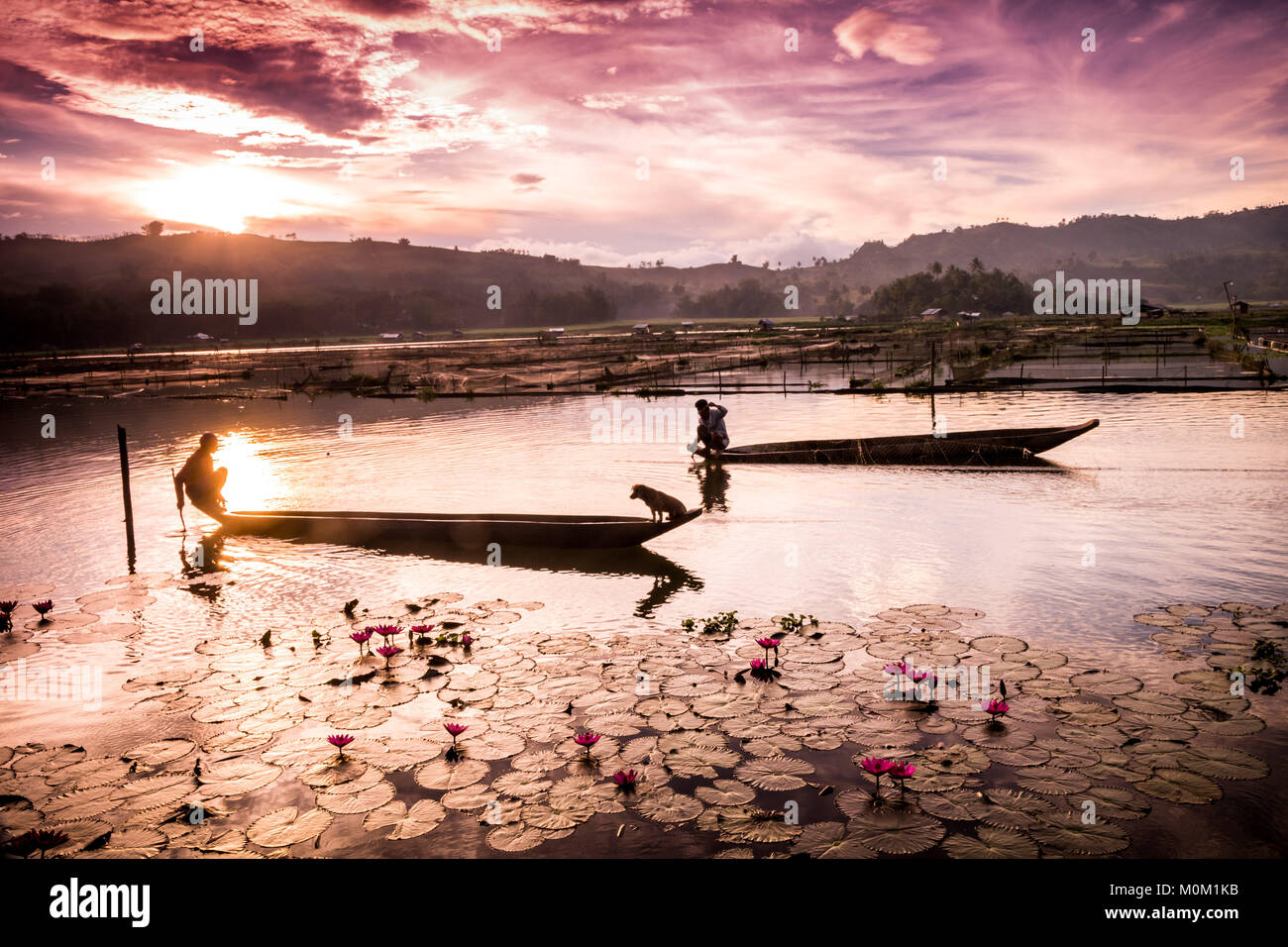 men board the traditional T'boli canoe 'owung' to check the fishing nets around the lake. Stock Photo