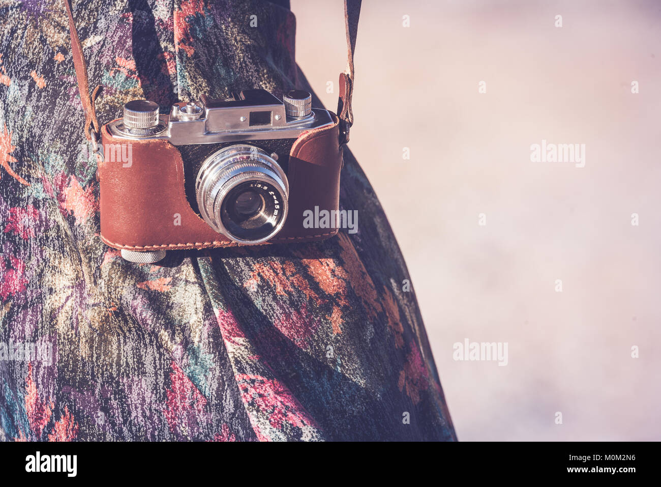 Girl wearing an old camera on the strap Stock Photo - Alamy