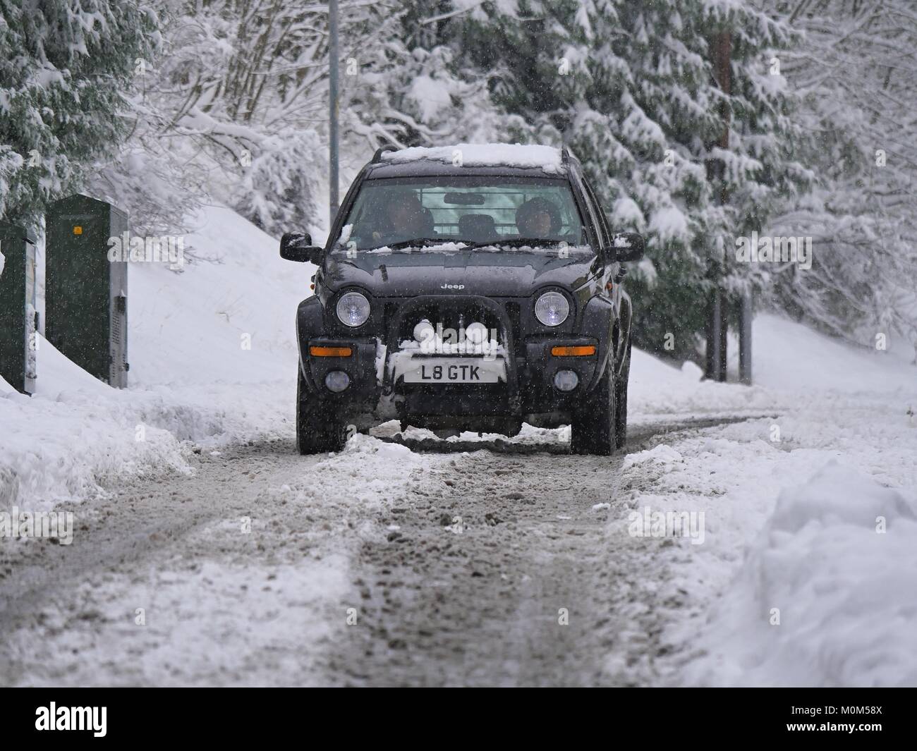 4x4 Jeep driving along road through snow in West Malvern UK Stock Photo
