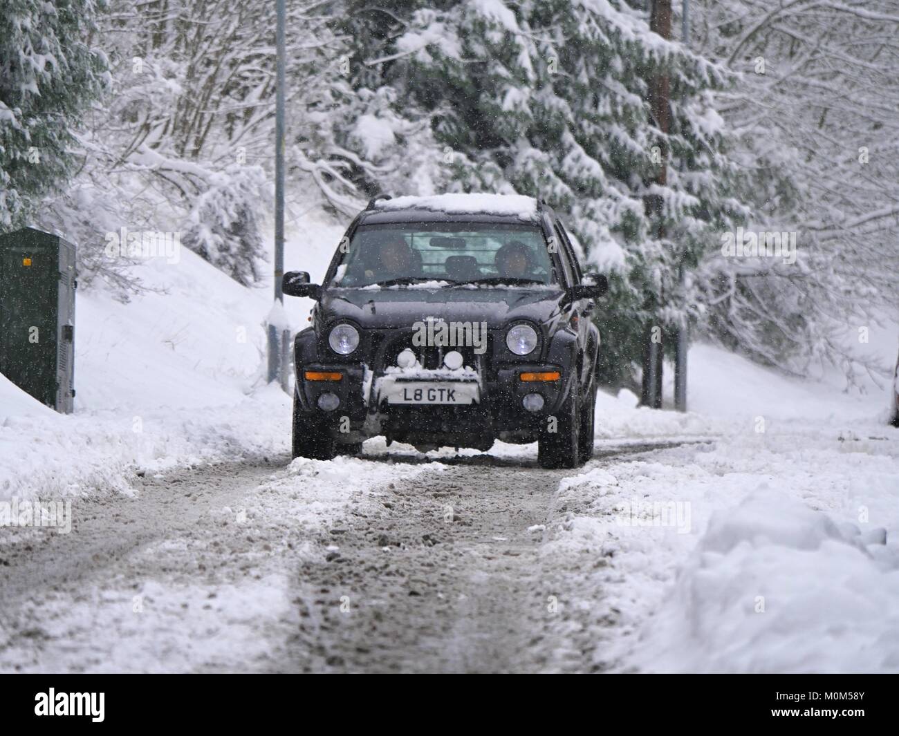 4x4 Jeep driving along road through snow in West Malvern UK Stock Photo