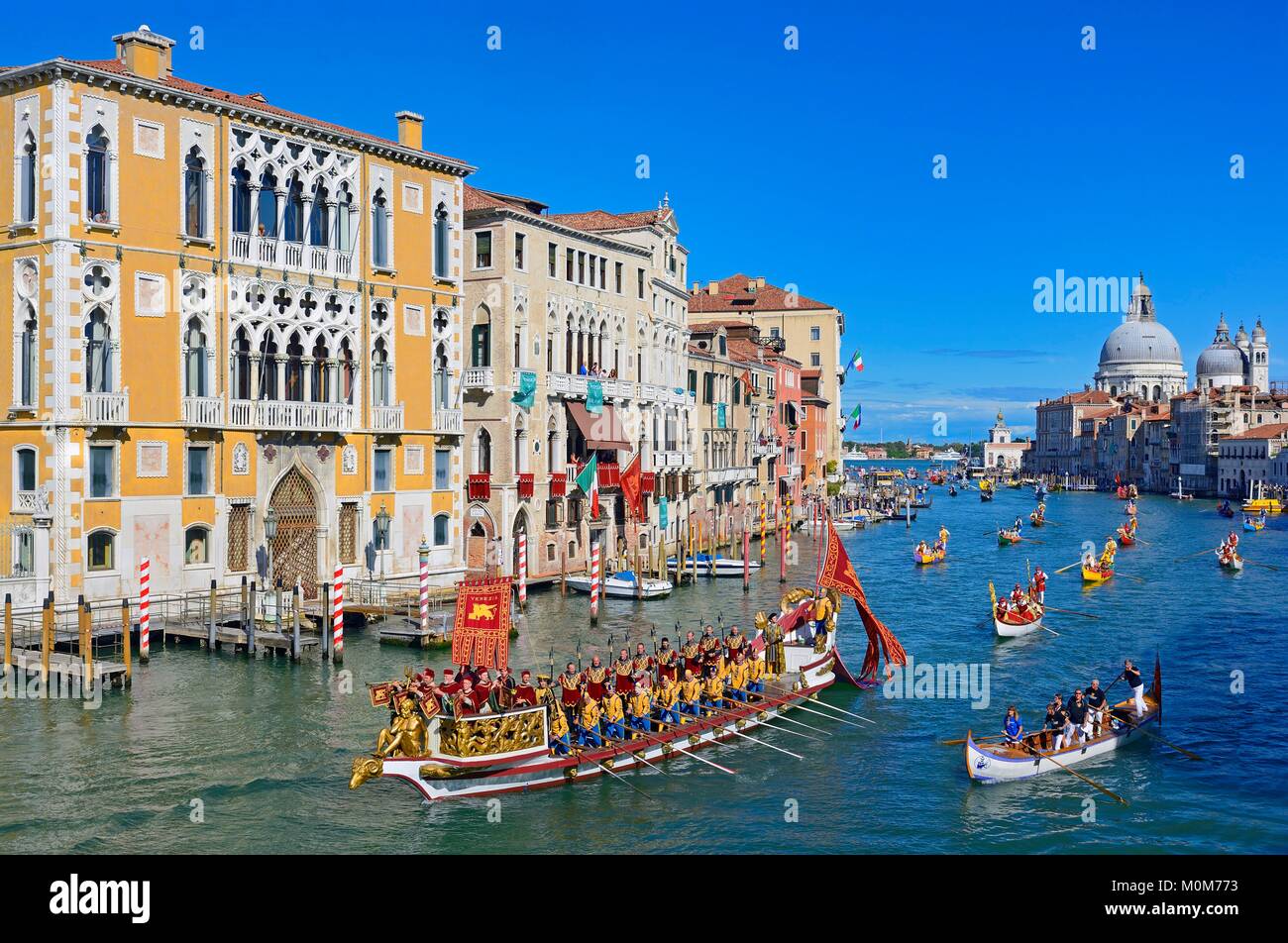 Italy,Veneto,Venice listed as World Heritage by UNESCO,the historical regatta on the Grand Canal with the the replica of the Bucentaur,state barge of the doges,Cavalli Franchetti palace on the left and Santa Maria Della Salute church in the background Stock Photo